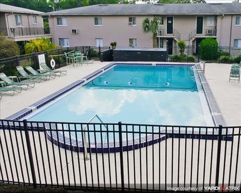 a swimming pool with a wrought iron fence around it
