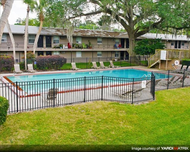 a swimming pool with a wrought iron fence around it