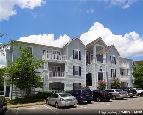 an apartment building with cars parked in front of it
