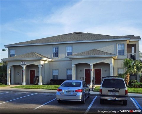a house with two cars parked in a parking lot