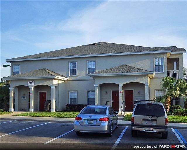 a house with two cars parked in a parking lot