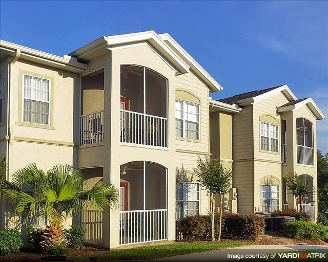 an apartment building with palm trees in front of it
