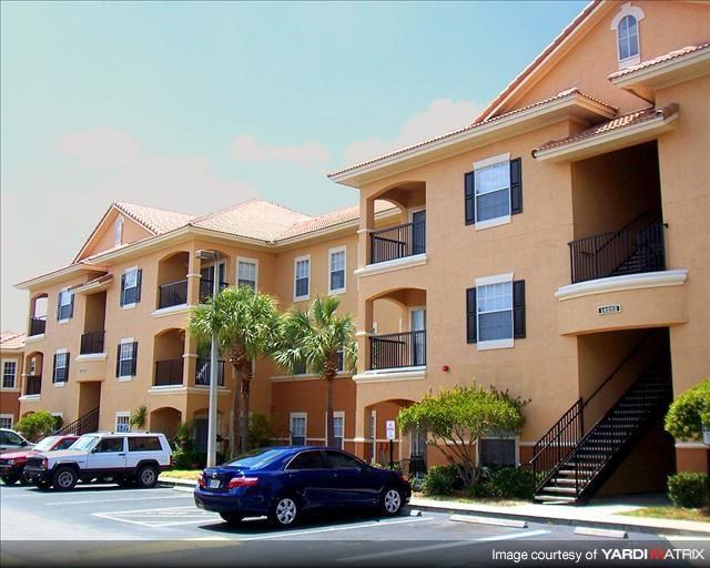 an apartment building with cars parked in front of it