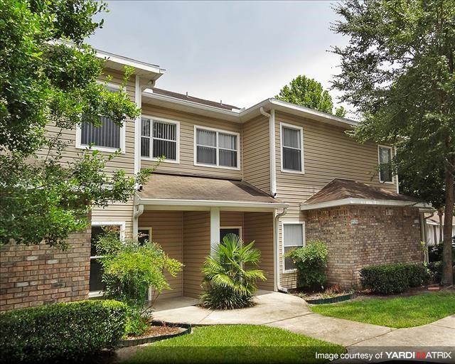 a brown house with a sidewalk in front of it