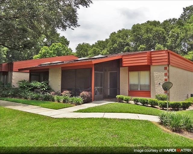 a house with a red roof and a sidewalk