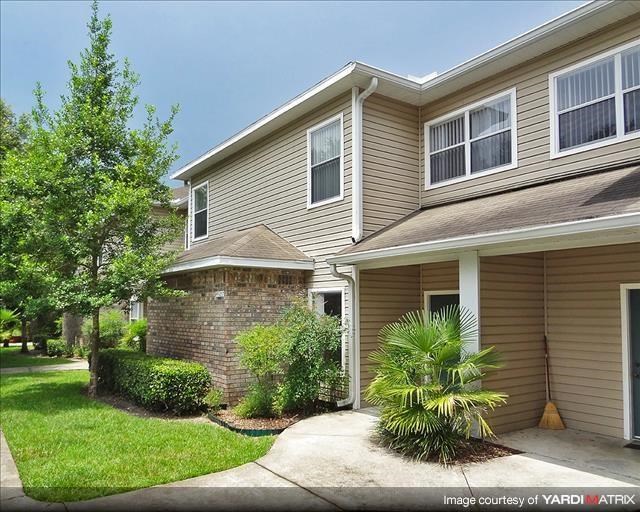 a brown house with a palm tree in front of it