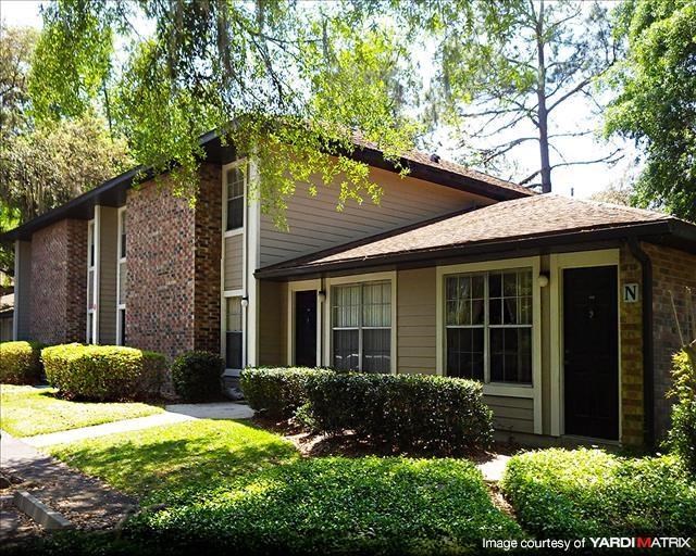 a small house with a lawn and trees