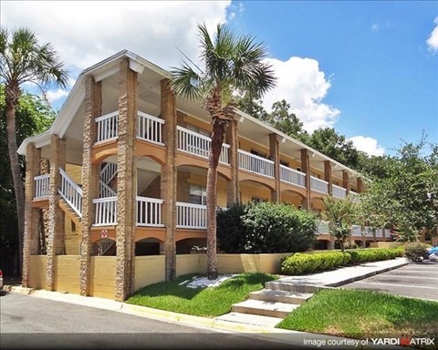 an apartment building with palm trees in front of it