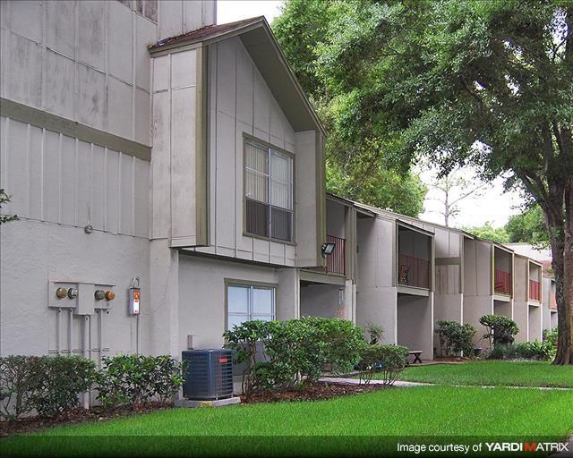 an apartment building with green grass and trees
