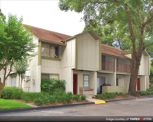 a white apartment building with a red door