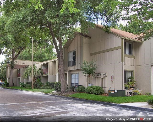an apartment building with trees in front of it