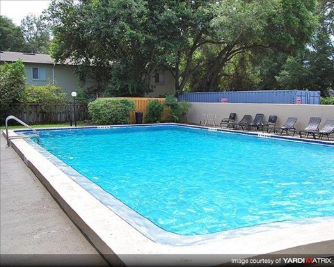 a large swimming pool with chairs around it