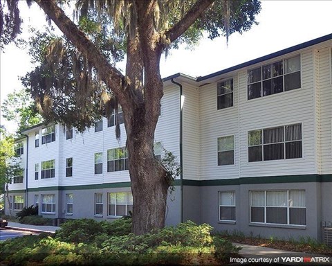 a apartment building with a tree in front of it