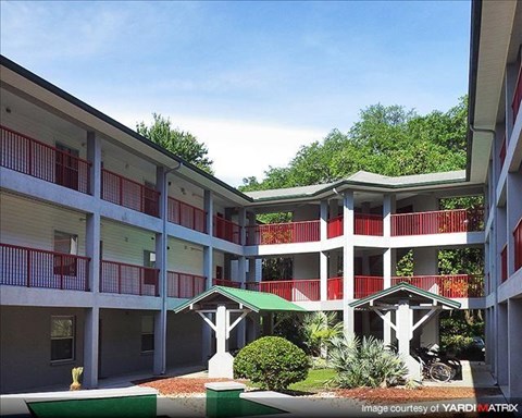an apartment building with red balconies and a courtyard
