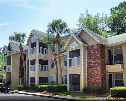 an apartment building with palm trees in front of it