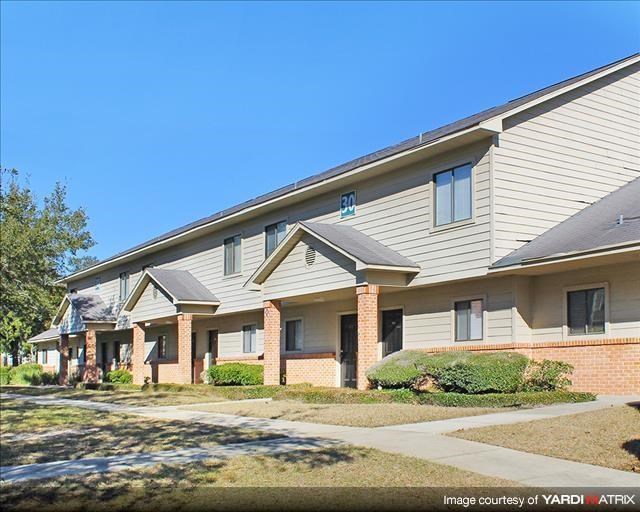 an apartment building with brick and white siding