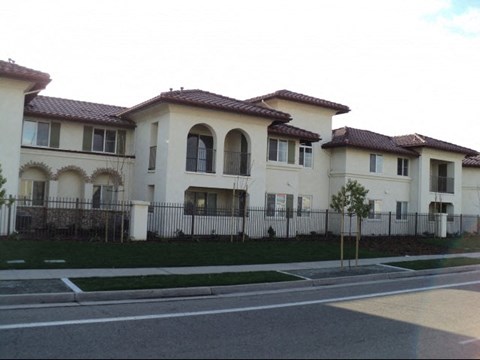 a group of white houses behind a fence