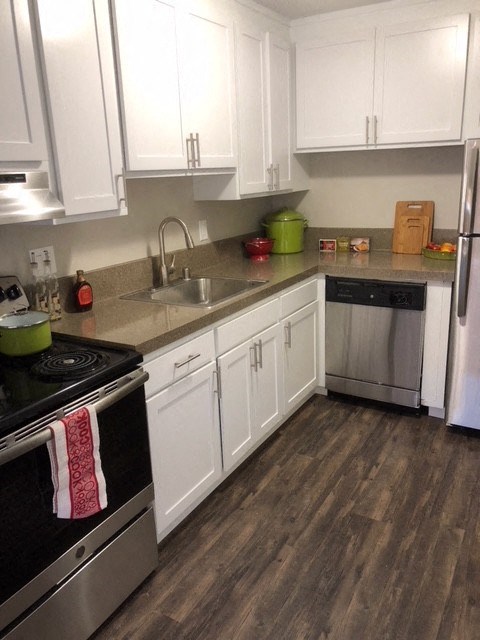 Walnut Creek Apartments - Kitchen with Stainless Steel Appliances, Wood Flooring, and White Cabinets