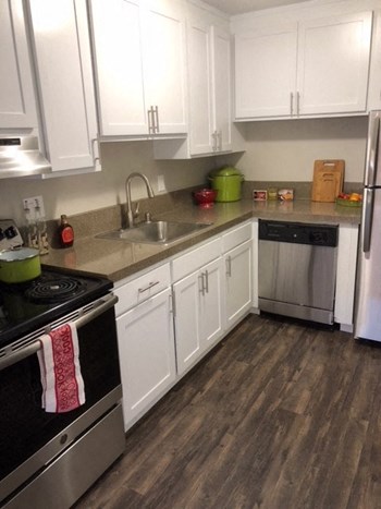 Walnut Creek Apartments - Kitchen with Stainless Steel Appliances, Wood Flooring, and White Cabinets - Photo Gallery 5