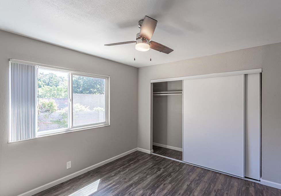 Two-Bedroom Apartments in Walnut Creek, CA - Creekside Terrace - Bedroom with Wood-Style Floors, Sliding Door Closet, and a Large Window