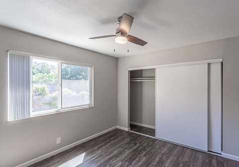 an empty living room with a ceiling fan and a window