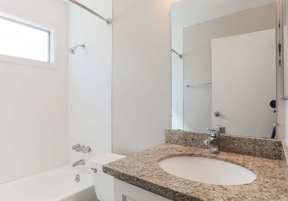 Apartments in Walnut Creek - Creekside Terrace - Bathroom with Granite-Style Sink, Bathtub, and Large Mirror