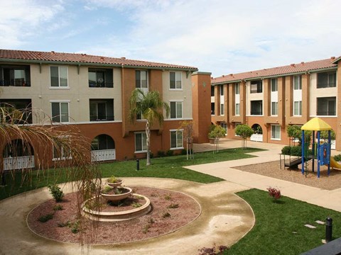 A courtyard with a fountain and a playground.
