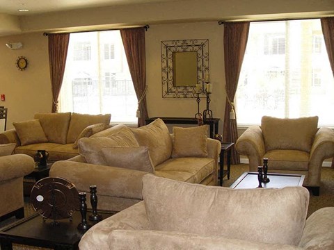 A living room with beige couches and a black coffee table.