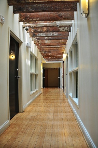 a long corridor with wooden floors and exposed beams on the ceiling