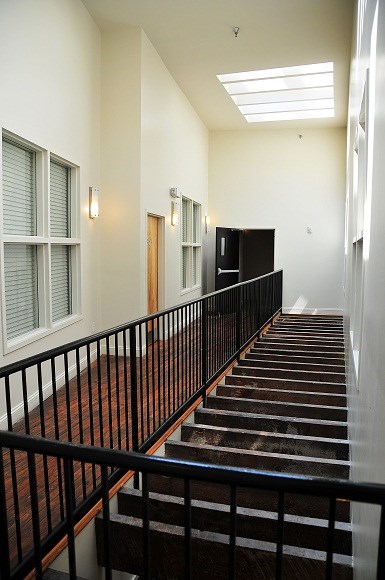 a staircase in a building with a black railing and a window