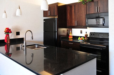 a kitchen with a black counter top and a sink