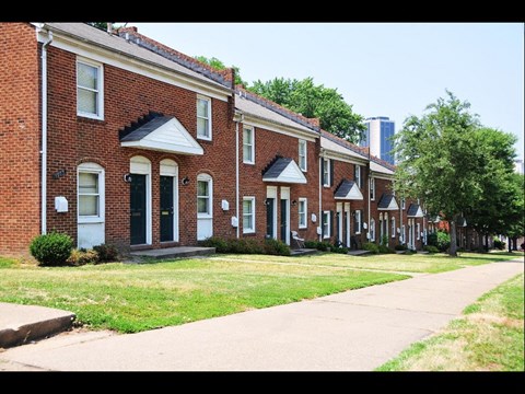 a row of brick houses on the side of a sidewalk