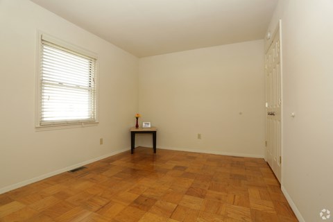 a room with wooden floors and a window and a table