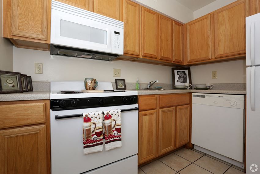 a kitchen with white appliances and wooden cabinets