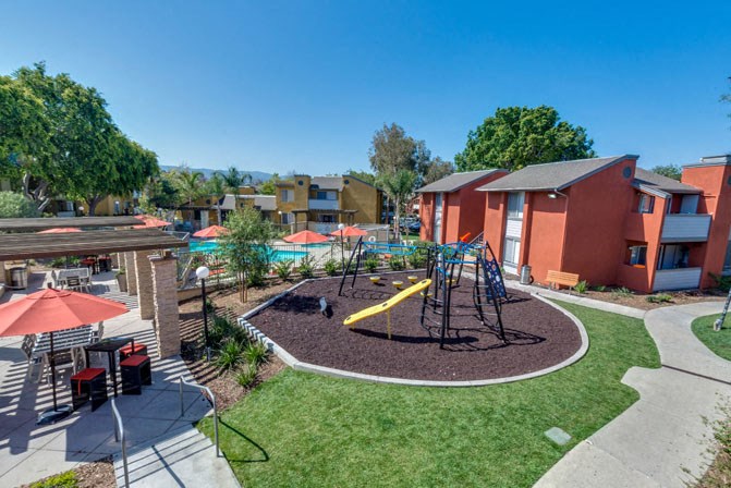 an aerial view of a playground with apartments in the background