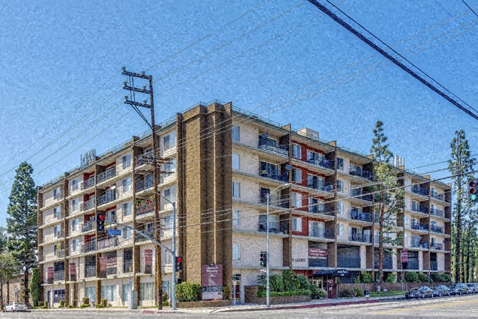 a large apartment building on the corner of a street