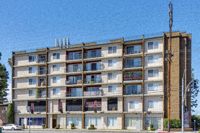 an apartment building with a blue sky in the background