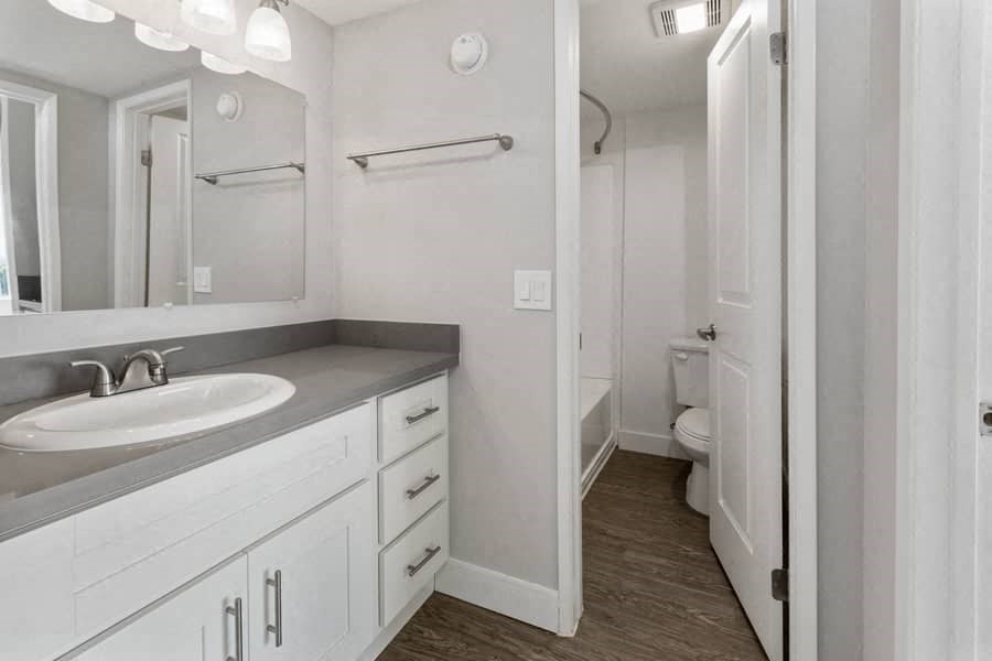 a white bathroom with a sink and a mirror