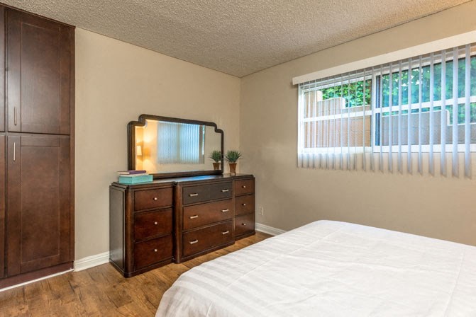 a bedroom with a bed and a dresser and a window
