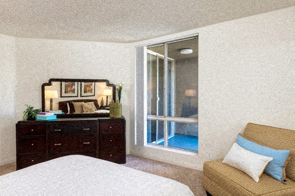 a bedroom with a bed and a dresser and a window