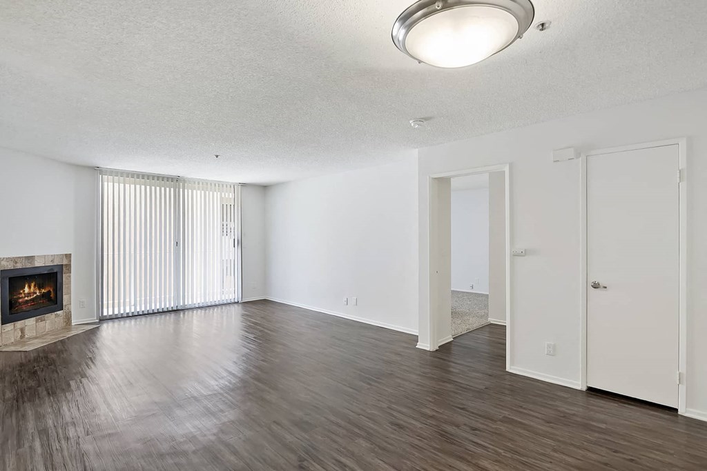 an empty living room with wood flooring and a fireplace