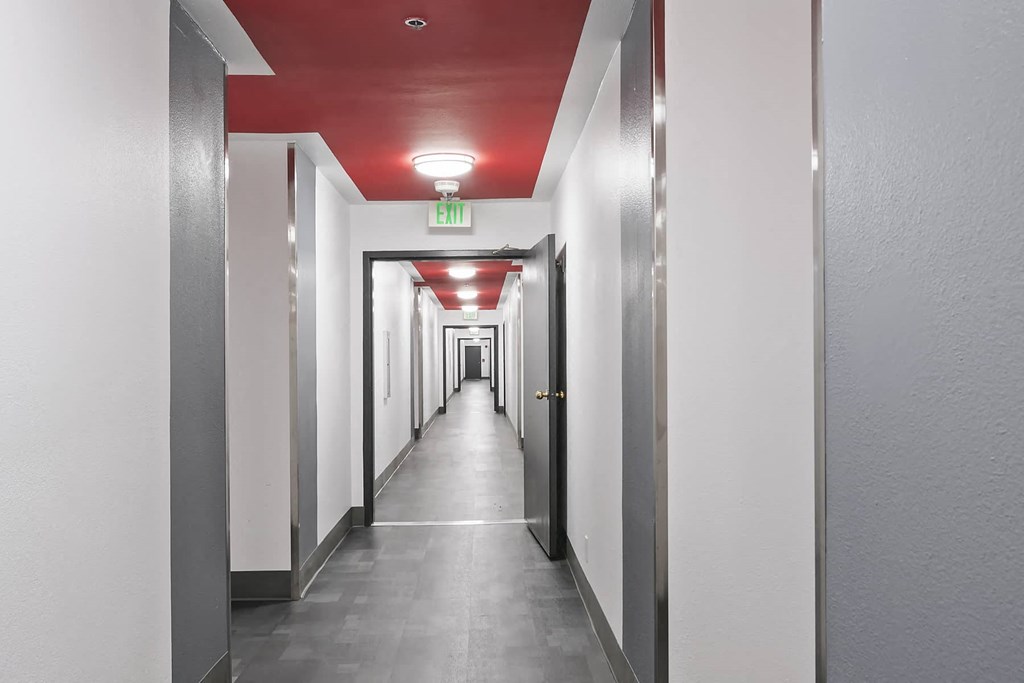 a long hallway with a red ceiling and white walls