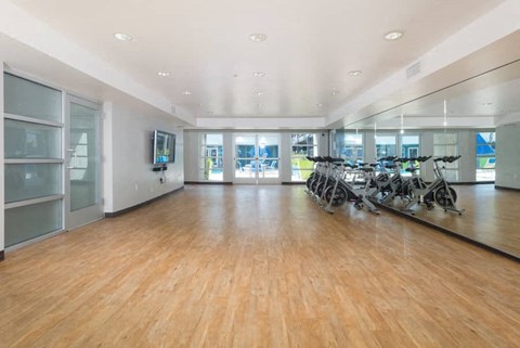 a fitness room with a wood floor and bikes in it