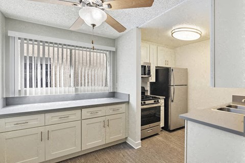 a kitchen with white cabinets and a refrigerator and a sink