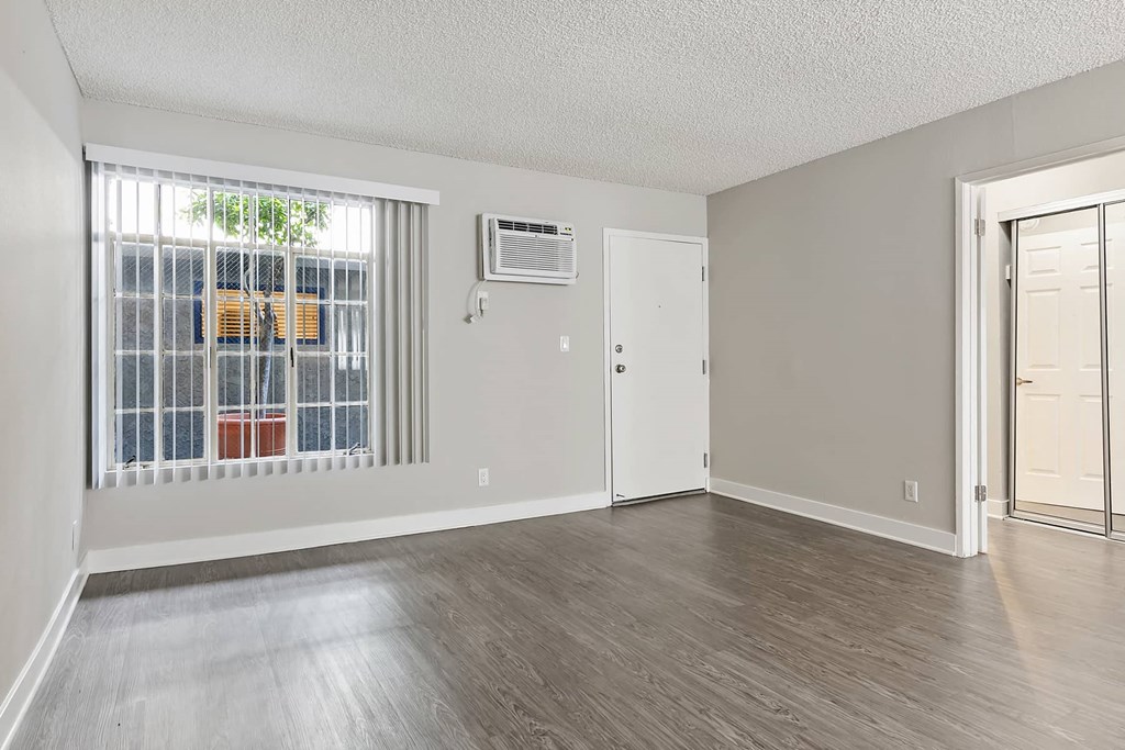 an empty living room with a large window and a door