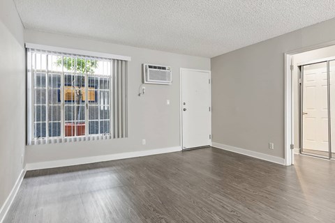 an empty living room with a large window and a door