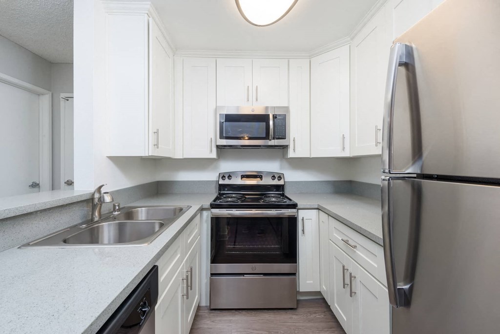 a kitchen with white cabinets and stainless steel appliances