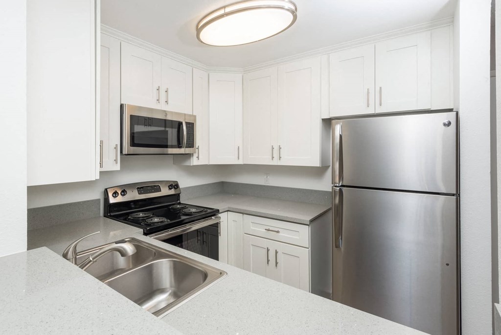 a kitchen with stainless steel appliances and white cabinets