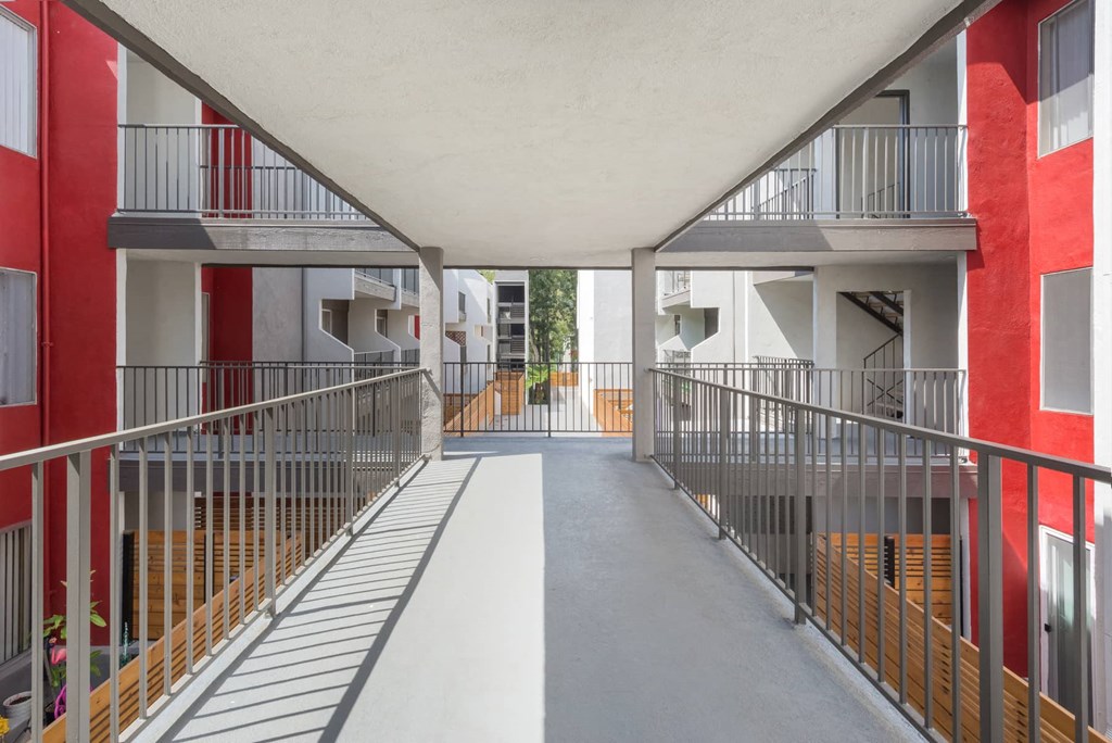 a corridor with metal fences and balconies in a building