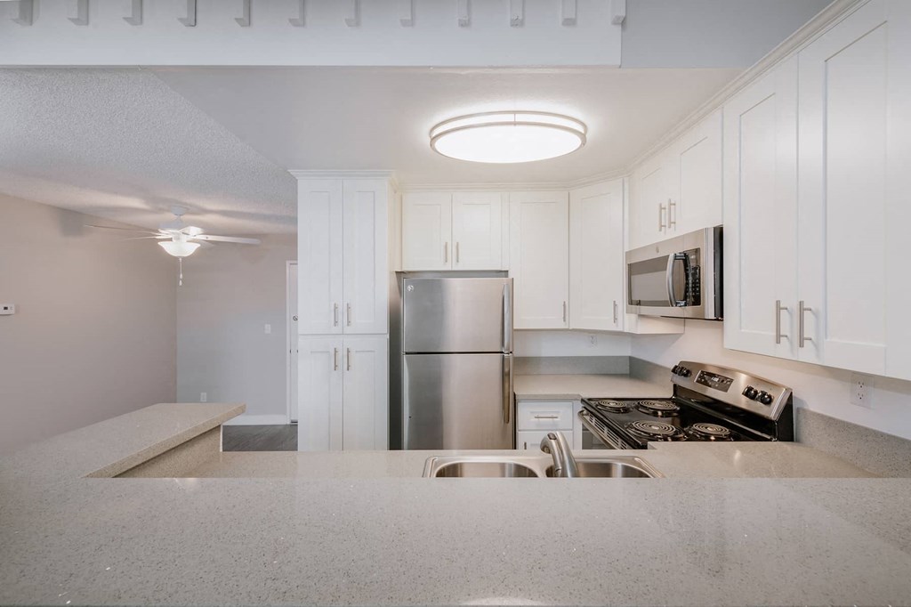 a kitchen with white cabinets and a stainless steel refrigerator